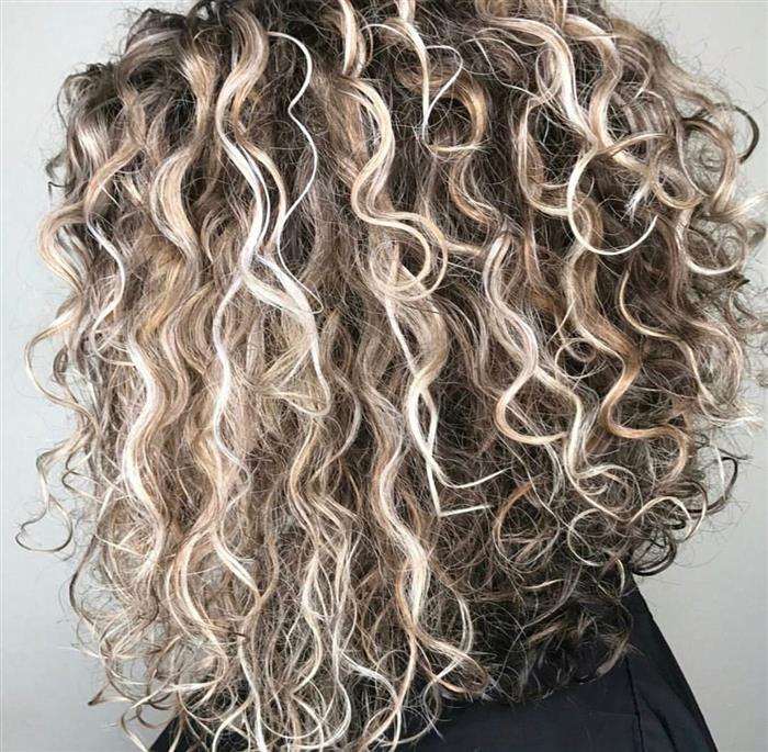 cabelos cacheados com luzes caramelo