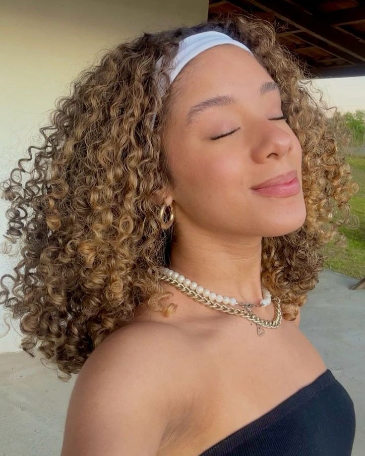 morena iluminada com loiro mel cacheado