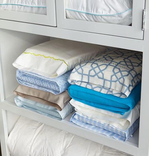 organização de roupas de cama no armário