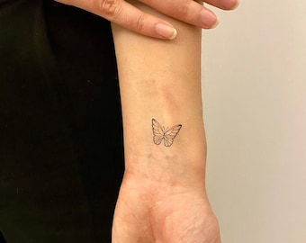 tatuagem borboleta pequena traço fino pulso