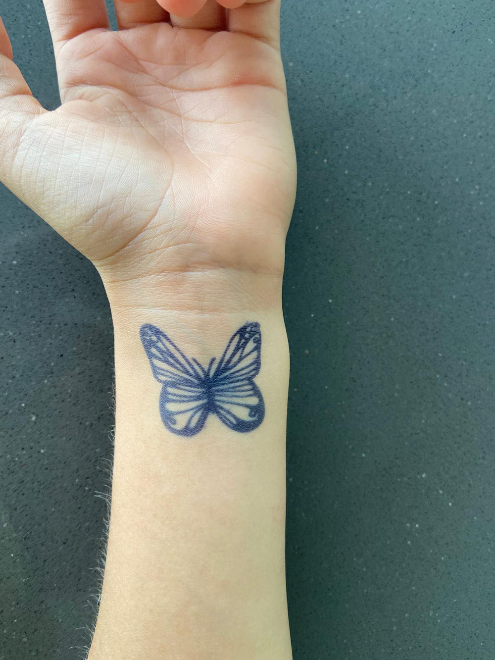 tatuagem borboleta pequena traço fino pulso