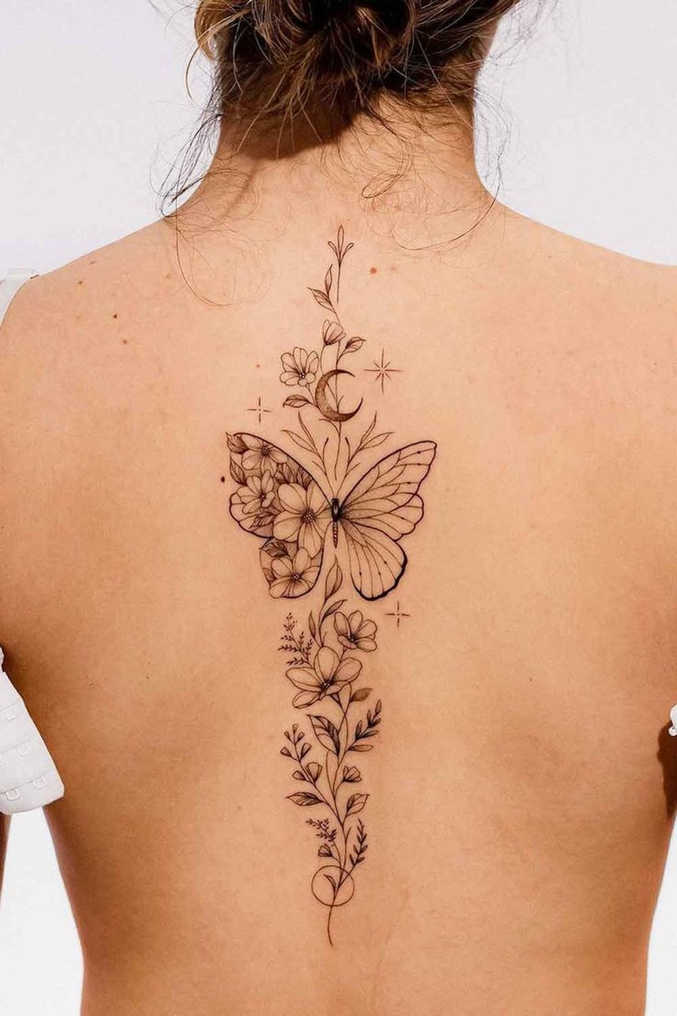 tatuagem feminina nas costas com flores
