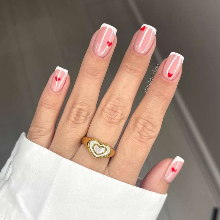 unhas vermelhas com flores brancas