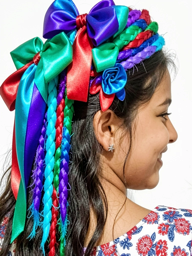 Menina com cabelo solto e meio-preso, flor de fita de cetim presa na lateral.