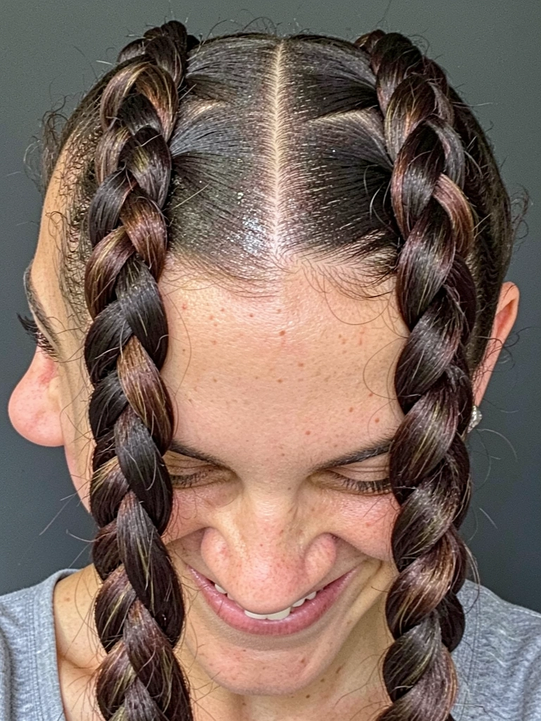 Mãos femininas segurando três mechas de cabelo, com a mecha da direita passando por baixo da do meio, close-up.
