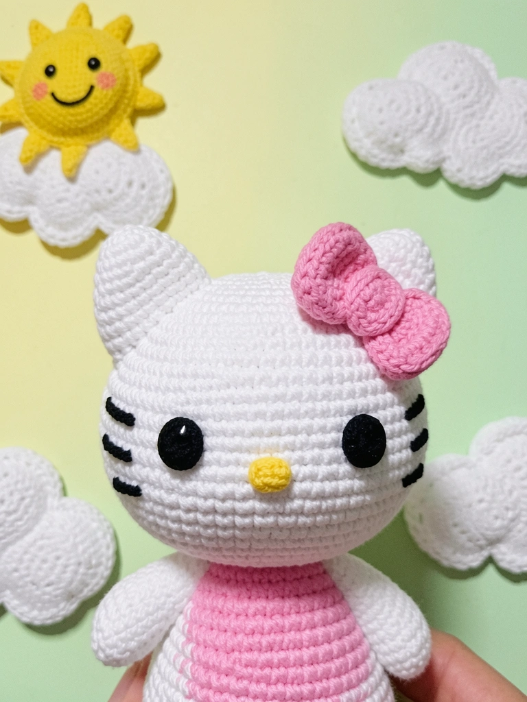 Close no rosto da Hello Kitty, sem boca, com laço vermelho na orelha esquerda.