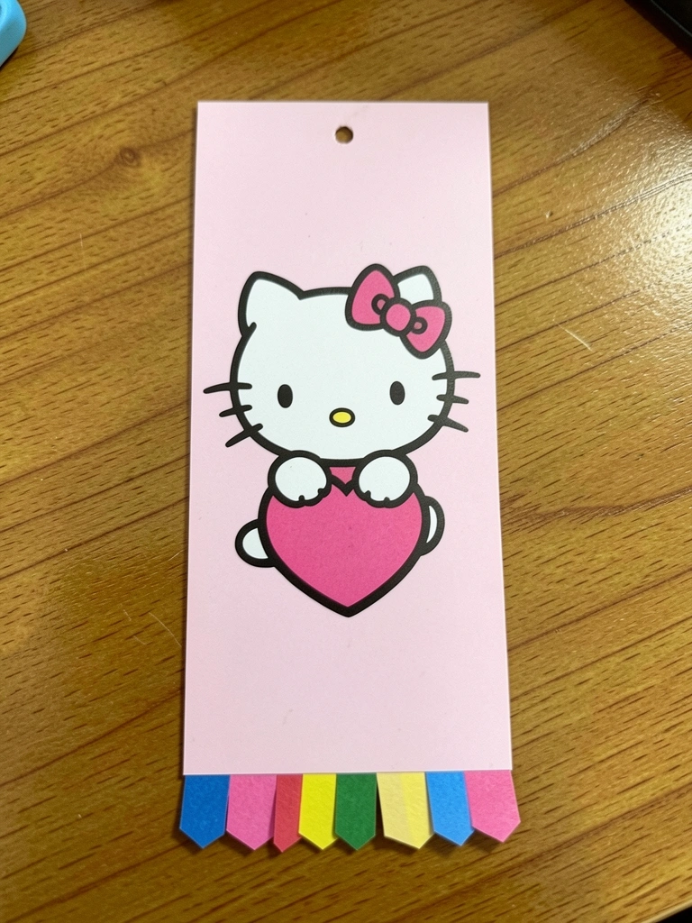 Marcador retangular com Hello Kitty e franja de papel colorido na ponta.