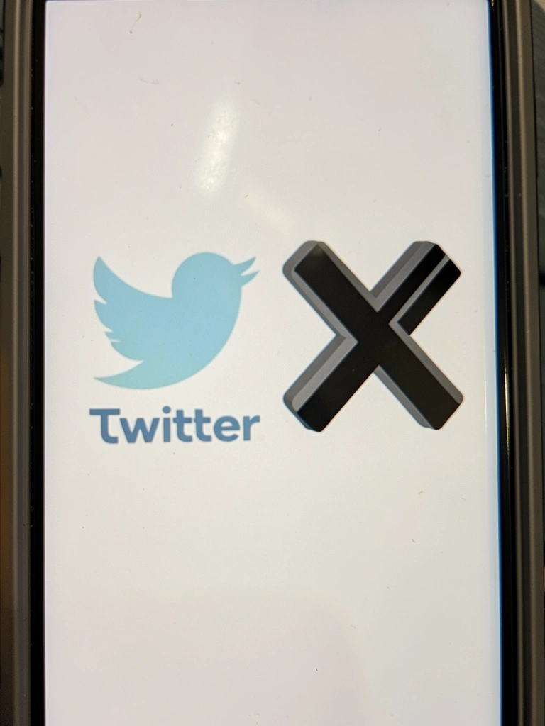 Logotipo preto do X ao lado do logotipo azul desbotado do Twitter sobre fundo branco.