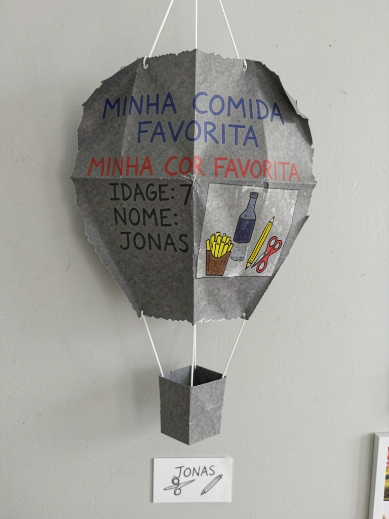 Balões Art Latex, papel fotográfico glossy, cola de silicone líquida e fitas de cetim sobre uma mesa.