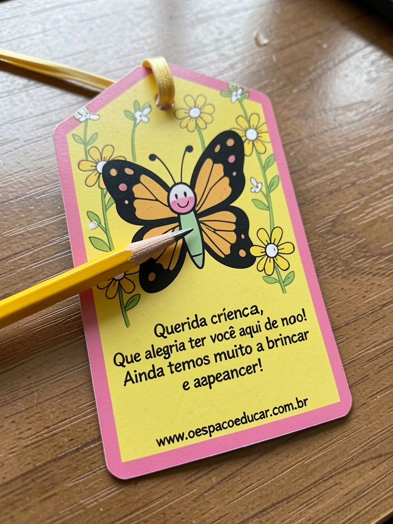 Cartão aberto em formato de marcador de página com um lápis preso por um elástico.