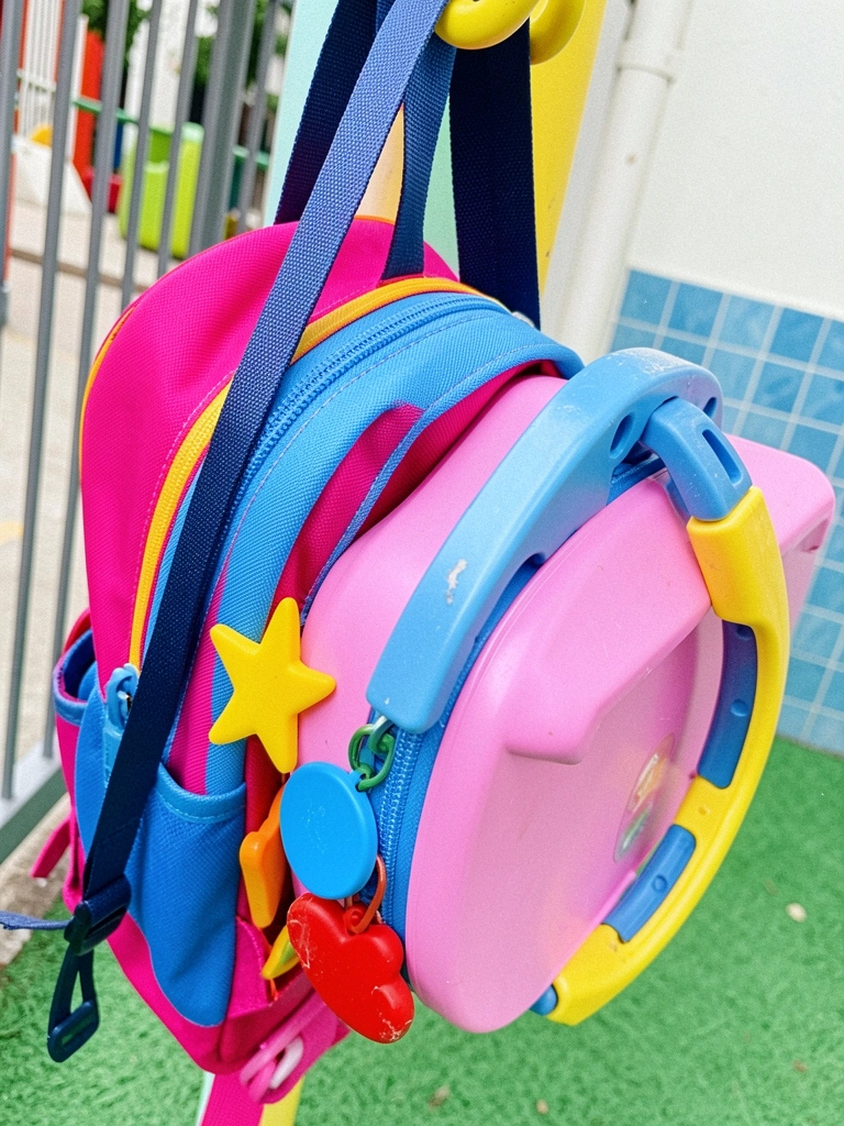 Etiquetas de silicone coloridas presas em uma mochila e lancheira, close-up.