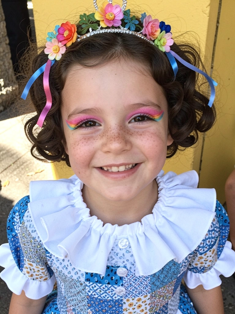 Tiara com flores e fitas em cabelo cacheado curto infantil.