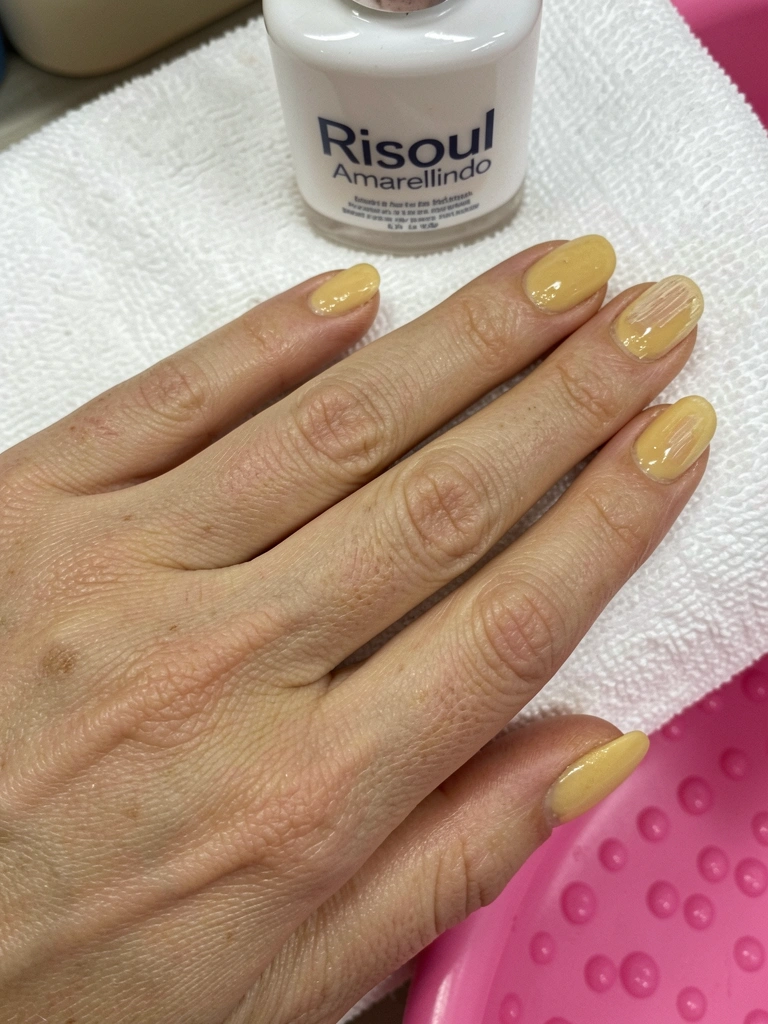 Colagem de fotos de celebridades exibindo unhas pintadas de amarelo manteiga.