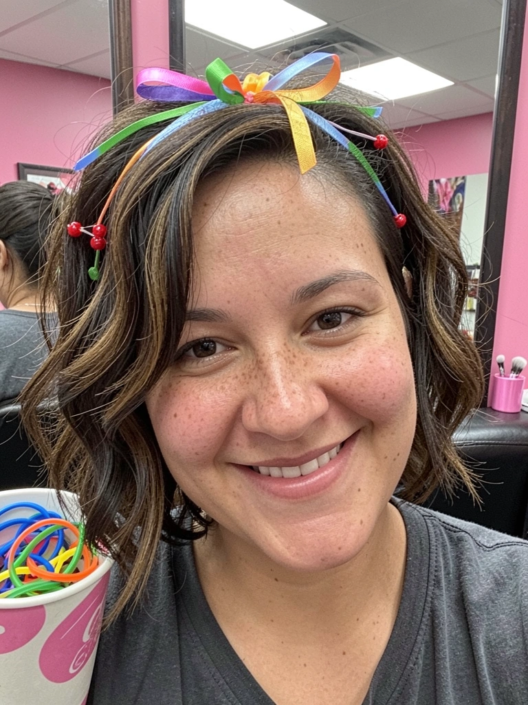 Cabelo curto com ondas suaves e tiara de fitas coloridas.