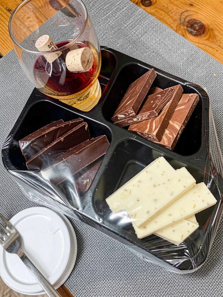 Barras de chocolate ao leite, meio amargo e branco sobre uma superfície de mármore.